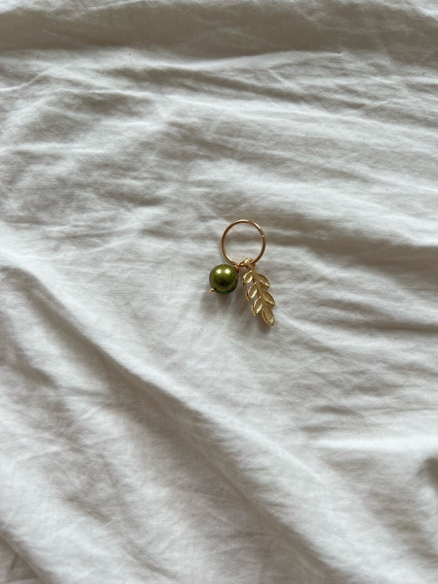 Mask marker with gold-plated leaf pendant and green freshwater pearl, 1 pc.